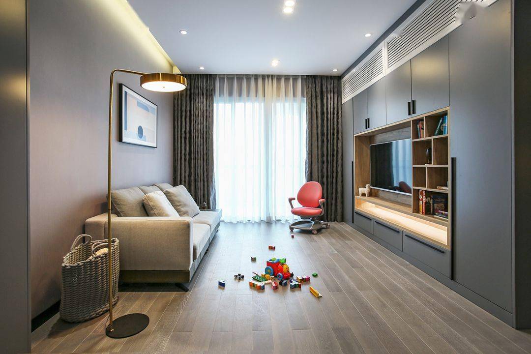 今天分享的是一套建筑面積102平米的現(xiàn)代輕奢風(fēng)三居室案例，屋主夫妻和女兒、母親一家四口人居住，整體來說是比較緊湊的剛需三房案例，設(shè)計(jì)師以輕松、時(shí)尚的灰色調(diào)作為主色，搭配格調(diào)滿滿的木質(zhì)家具，營造出簡約、輕奢的感覺。    平面布置圖    入戶玄關(guān)和餐廳連在了一起，利用了入戶門側(cè)方的墻面來做上一整墻的柜子，把鞋柜和餐邊柜結(jié)合在一起使用，更為省空間。    復(fù)古的木質(zhì)餐桌椅到灰色調(diào)的背景，金屬質(zhì)感的吊燈，整個(gè)餐廳看起來非常有格調(diào)感。在餐桌椅側(cè)方加上隔板的設(shè)計(jì)，增強(qiáng)儲物能力。    位于餐廳另一側(cè)的就是客廳空間了，客廳的茶幾被舍棄，中間留空方便作為孩子的娛樂區(qū)，米色布藝沙發(fā)和暖灰色背景墻讓人感覺更加溫馨。    客廳的電視背景墻則是被利用起來做了收納，整墻的柜子留空電視周邊的部分區(qū)域，加上藏光之后使用更方便，看起來也更大氣。    廚房內(nèi)部的櫥柜延續(xù)了客餐廳的柜子顏色，深灰色的大理石墻磚搭配灰色的啞光地磚，整個(gè)廚房看起來很有現(xiàn)代感。    臥室選擇了以藍(lán)灰色為主，在臥室頂部吊頂內(nèi)加上藏光，用吊燈、臺燈等代替主燈，讓臥室看起來更為簡潔。    在主臥室里還有一個(gè)迷你的衣帽間，U字形布局的柜子把角落空間充分用上。衣帽間外的床頭柜改成了梳妝臺，使用起來更加方便。    老人房選擇了榻榻米床組合衣柜和書桌的設(shè)計(jì)，榻榻米的安全性會更高一些，加上一張書桌也方便屋主母親看看書。    衛(wèi)生間內(nèi)部是三角形的布局方案，鉆石形的淋浴房做在了轉(zhuǎn)角處，兩側(cè)擺放洗手臺和馬桶。洗手臺上方的鏡柜做了藏光的設(shè)計(jì)，看起來更時(shí)尚。